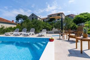 a swimming pool with chairs and a table at Villa Andante in Trogir