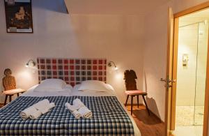 1 dormitorio con 1 cama con toallas en Au gre des chateaux, en Goxwiller