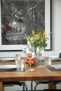 a table with wine glasses and a vase of flowers at Dünenblick Apartments in Helgoland