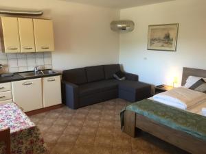uma sala de estar com uma cama e um sofá em Apartma Valmarin em Spodnje Škofije