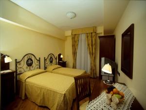 Un dormitorio con 2 camas y una mesa con un bol de fruta en La Locanda di Castromediano, en Castelmezzano