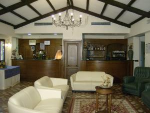 a waiting room with white chairs and a bar at La Locanda di Castromediano - Al Becco della Civetta in Castelmezzano