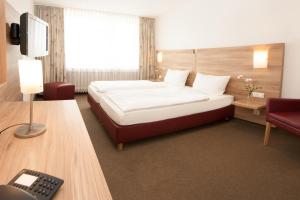 a hotel room with a bed and a desk at Hotel Schützenburg in Burscheid