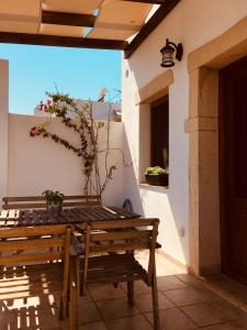 a wooden table and bench on a patio at Apocalypsis Houses in Skala