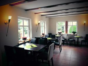 a dining room with tables and chairs and windows at Eiscafe&Pension Schumann in Bresewitz
