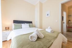 ein Schlafzimmer mit einem großen weißen Bett mit Handtüchern darauf in der Unterkunft Heart of the City in Athen