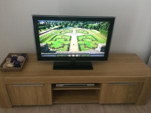 a flat screen tv sitting on top of a wooden entertainment center at Apartment Cesarica in Cesarica