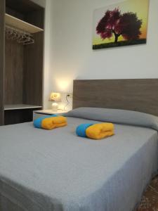 ロケタス・デ・マルにあるApartamentos Roquetas Playaのベッドルーム1室(黄色と青の枕付きのベッド1台付)