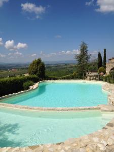 a large swimming pool with blue water at Residenza Cornino in Castellina in Chianti