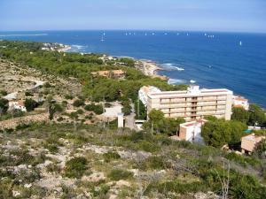 a building on top of a hill next to the ocean at Apartments Las Vinas in Denia