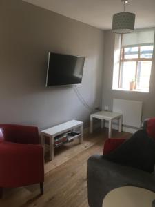 a living room with a flat screen tv on the wall at Victorian Church Flat 3 in Oswestry