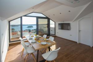 a dining room with a table and chairs and a large window at Villa Marijeta Hvar in Hvar