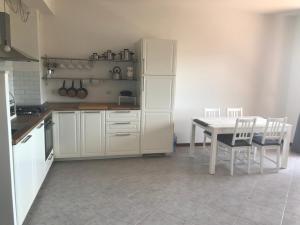 a kitchen with white cabinets and a table and chairs at Appartamento Oscar in Tuoro sul Trasimeno +21 photos
