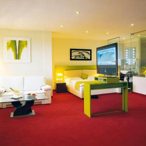 1 dormitorio con 1 cama, TV y sofá en Hotel Restaurant Pusswald, en Hartberg