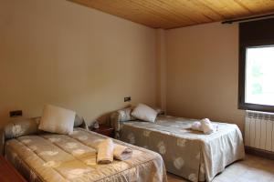 1 dormitorio con 2 camas y ventana en Apartamentos Turísticos Can Rocamora en Aren