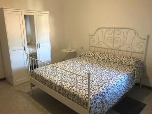 a bedroom with a bed with a blue and white comforter at Appartamento Oscar in Tuoro sul Trasimeno