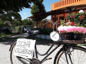 Una bicicleta con un cartel con flores en una cesta en La Campagnola Trattoria con Alloggio, en Misano Adriatico