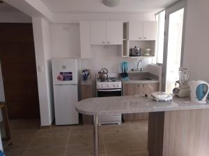 a kitchen with white appliances and a marble counter top at Apartamentos Beaterio Yanahuara in Arequipa