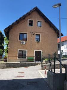 un edificio con un banco verde delante de él en Apartma Mahnič en Postojna