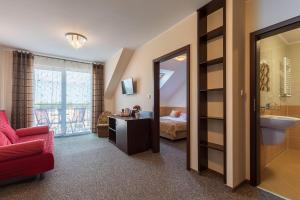 pokój hotelowy z czerwoną kanapą i łazienką w obiekcie Willa Grawit we Władysławowie