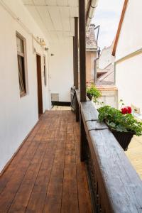 um alpendre vazio com piso em madeira e plantas em Musik Apartments Old Town em Sibiu