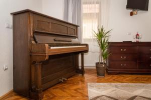 um piano velho numa sala de estar com uma cómoda em Musik Apartments Old Town em Sibiu