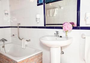 uma casa de banho branca com um lavatório e um espelho em La Casona de Sobrepiedra em Sobrepiedra