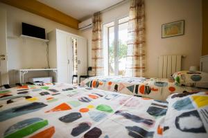 a bedroom with two beds and a window at BEB BRUSCE' FRANCO E TINA in Ragusa