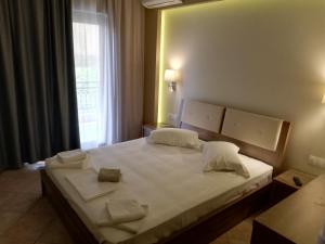 a bedroom with a large white bed with two pillows at Giannis & Foteini in Afitos