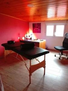 a room with a table and a red wall at Albergue de Peregrinos La Espiral in Finisterre