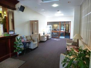 un vestíbulo con una zona de espera con sillas y mesas en Norseman Hotel, en Wick