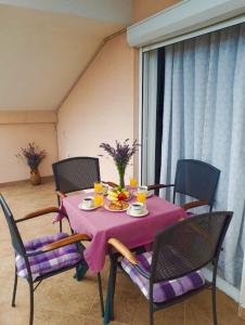 a table with a pink table cloth on it with chairs at Apartments Brčić in Kaštela