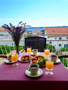 un tavolo con cibo e bevande su una tovaglia viola di Apartments Brčić a Kaštela (Castelli)