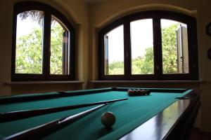 a pool table in a room with three windows at Villa Sarno in Montesilvano