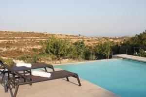 a swimming pool with two lounge chairs next to it at Agriturismo Leone in Testa dellʼAcqua