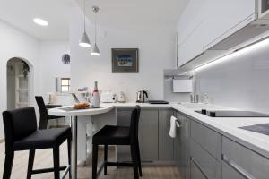 a white kitchen with a table and chairs in it at LUXOR Hvar - Main Square Apartments in Hvar