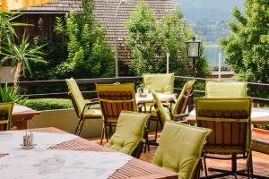a patio with tables and chairs on a balcony at Hotel Kanz in Egg am Faaker See