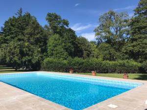 una piscina en un patio con árboles en Chambre d'hôte Manoir de Clairbois, en Larçay