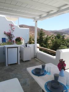 a white table with blue plates on a balcony at Evilou's House in Krotiri +31 photos