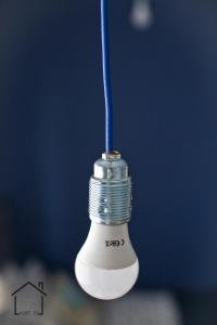 un primo piano di una lampadina con cordone blu di Hostel 33 a Trzebinia