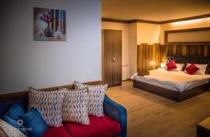 a hotel room with a bed and a couch at White Cedar Hotel &Resort in Al Arz