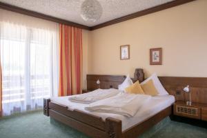 a bedroom with a bed and a large window at Hotel Kanz in Egg am Faaker See