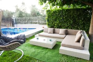 un patio trasero con sofá, sillas y piscina en Luxurious Villa Anastasia, en Zíria
