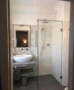 ein Bad mit einem Waschbecken und einer Glasdusche in der Unterkunft Robin Rooms in Montegranaro