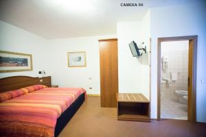 a bedroom with a bed and a bathroom with a toilet at Hotel I Tigli albergo diffuso in Corinaldo