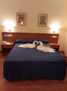 a hotel room with a bed with swans on it at Hotel Peña de Arcos in Arcos de la Frontera