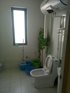 a bathroom with a toilet and three buckets in it at Wuwei Qiyou Space Capsule Hostel in Wuwei