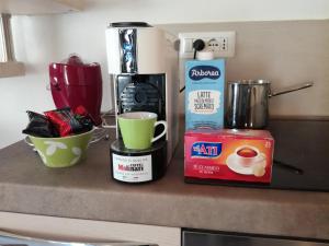 a counter with cups and a coffee maker on it at B&B Piazza di L'Ara in Tempio Pausania +27 photos