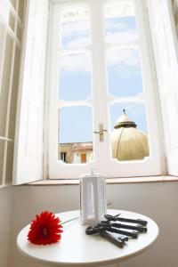 a white table with a window and a red flower on it at Vic Street B&B in Naples