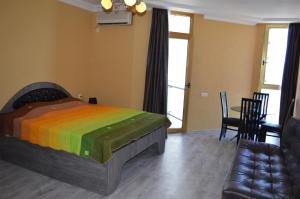 sypialnia z łóżkiem z kolorowym kocem w obiekcie ORBI plaza w mieście Batumi